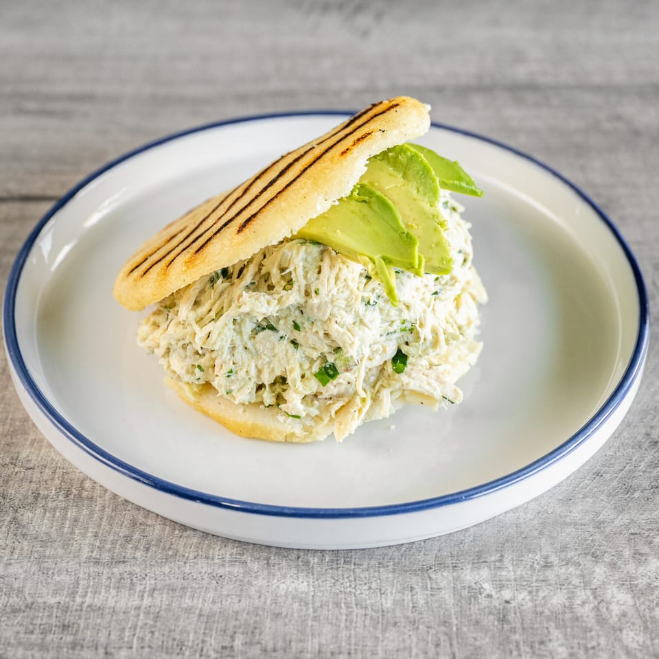 Calle El Hambre's Reina Pepiada arepa, filled with shredded chicken salad and sliced avocado.