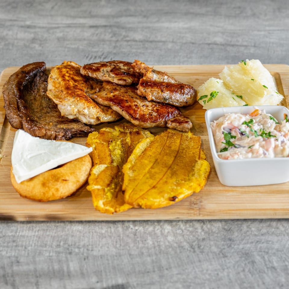 Calle El Hambre's Venezuelan platter with grilled meats, fried plantains, yuca, arepa with cheese, and salad.