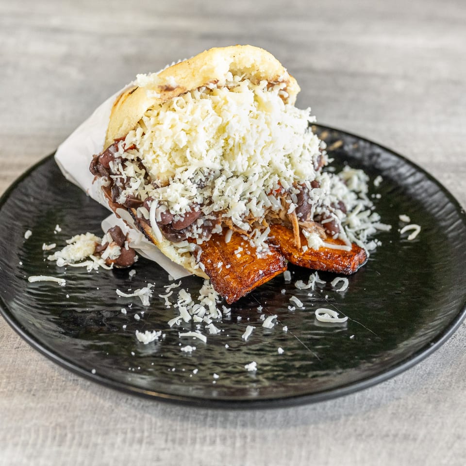 A Venezuelan arepa from Calle El Hambre, filled with beans, plantains, and shredded white cheese.