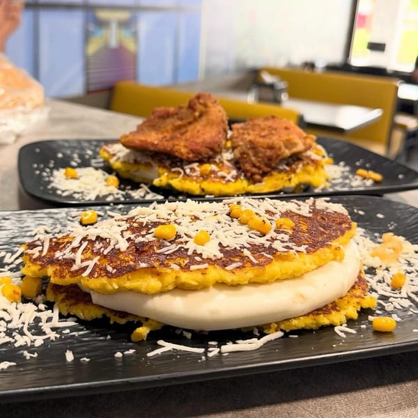 Two Venezuelan cachapas, one with cheese and corn, the other with fried chicken.